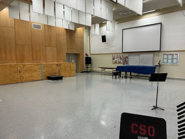 Classroom with a small stage and large projector board.
