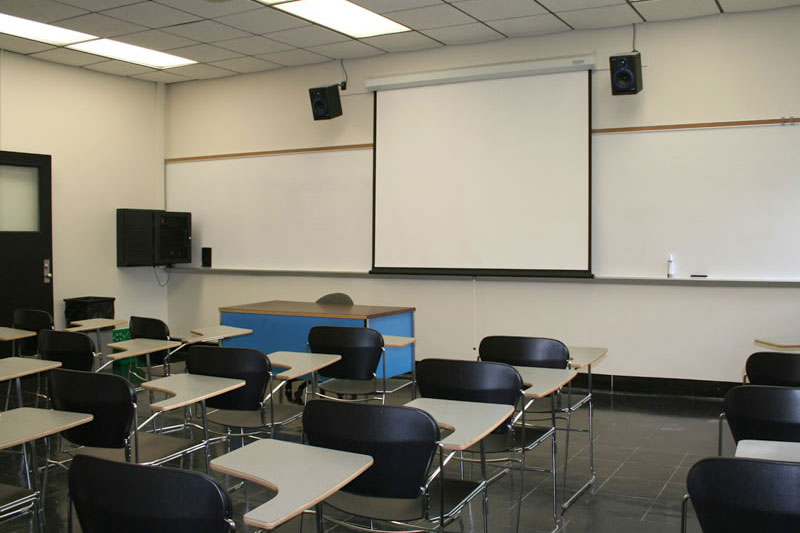 Fenton 166 front of the classroom with a large projector screen and whiteboard.