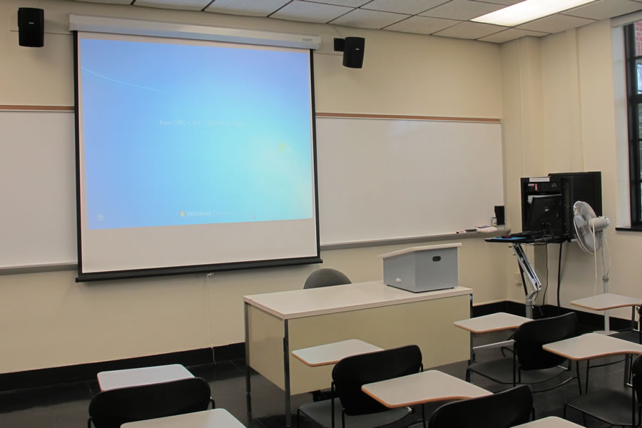 Fenton 174 Front of the classroom with a large whiteboard and projector screen.