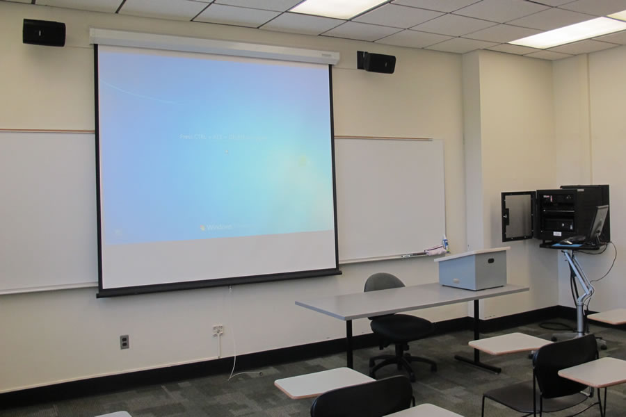 Fenton 175 front of classroom with a large white board and projector screen.