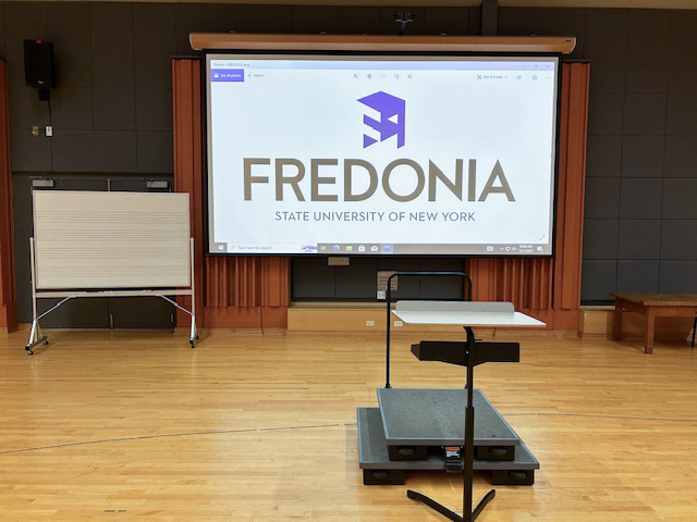 Front of the room with a large white board and projector screen