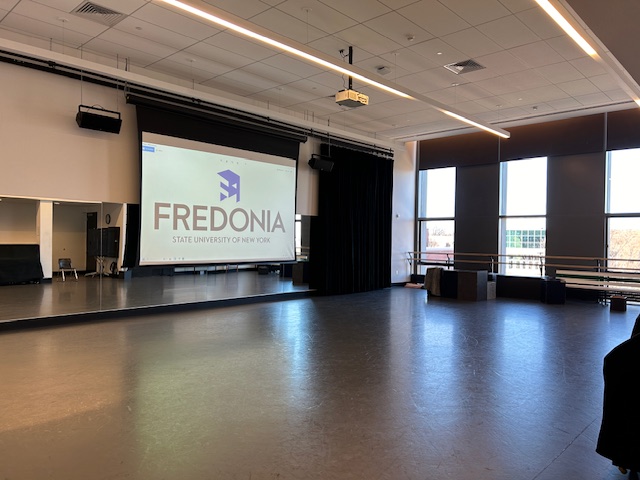 Front of the dance studio with a large projector screen.