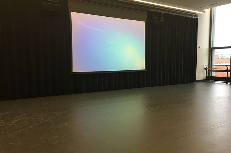Front of the classroom with a large projector screen.