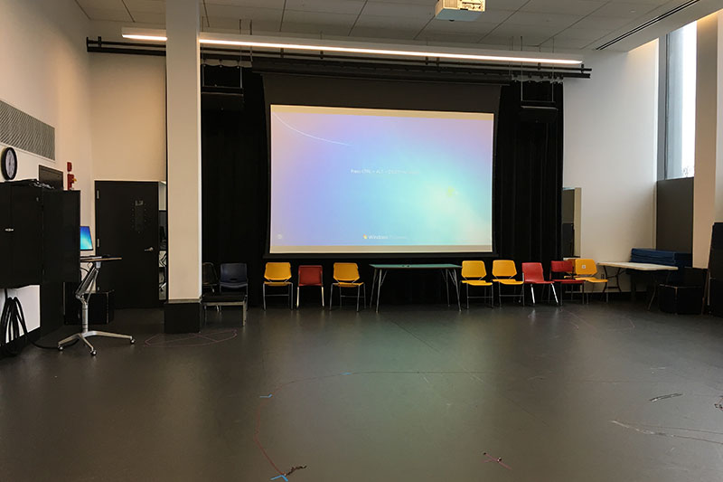 Front of the classroom with a large projector screen.