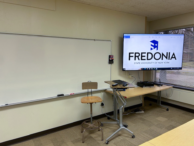 Front of the classroom with a large white board and TV