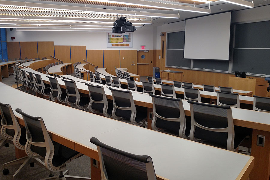 Front of the classroom with a large black board and projector screen.