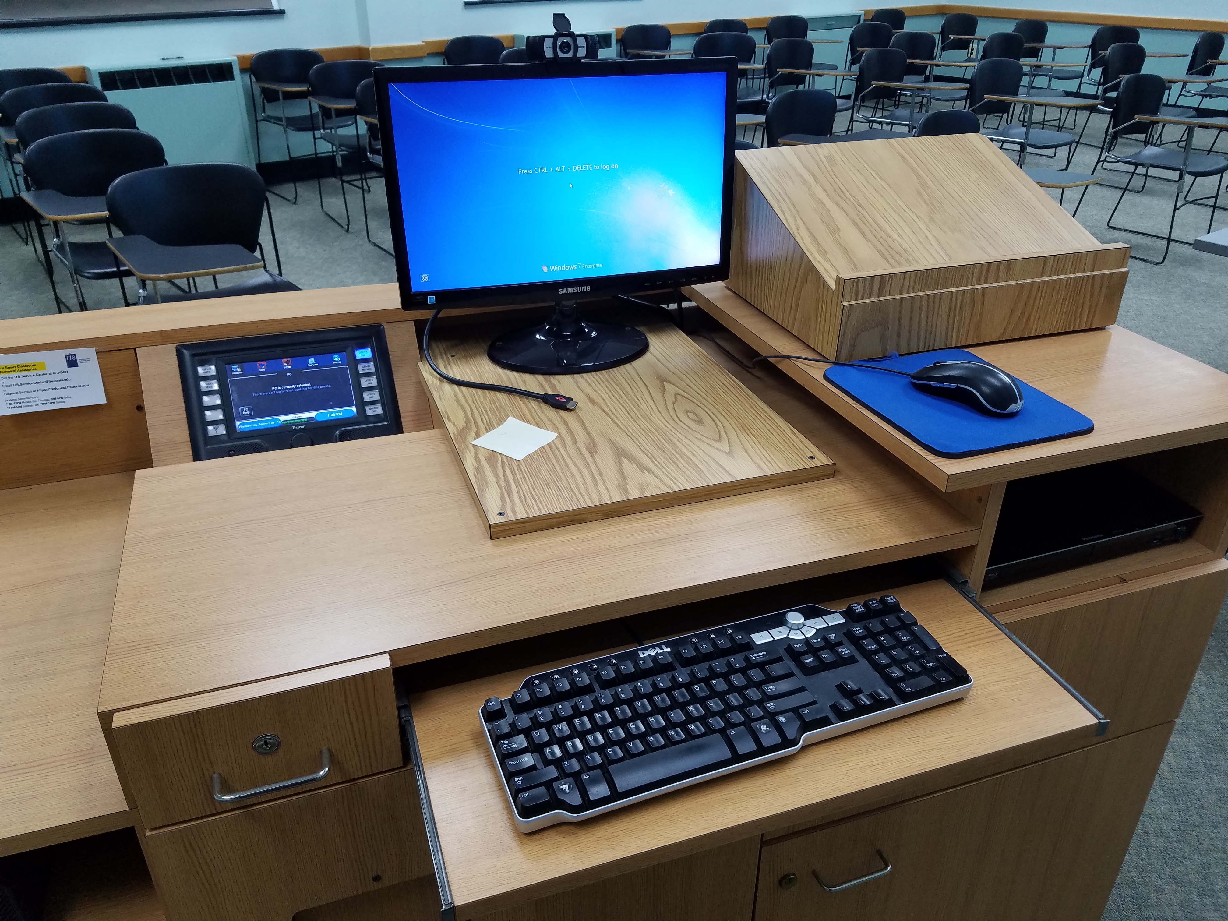 Teachers desk set up with a computer monitor and keyboard.