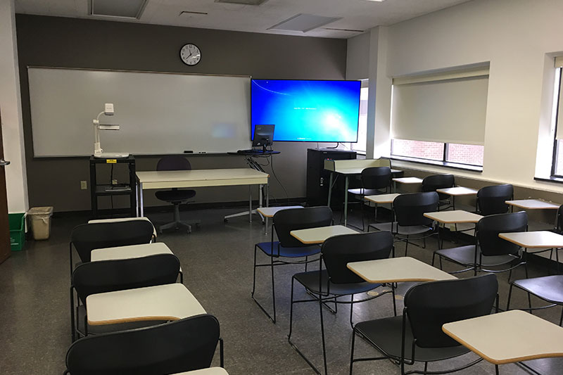 Front of the classroom with a large white board and TV.