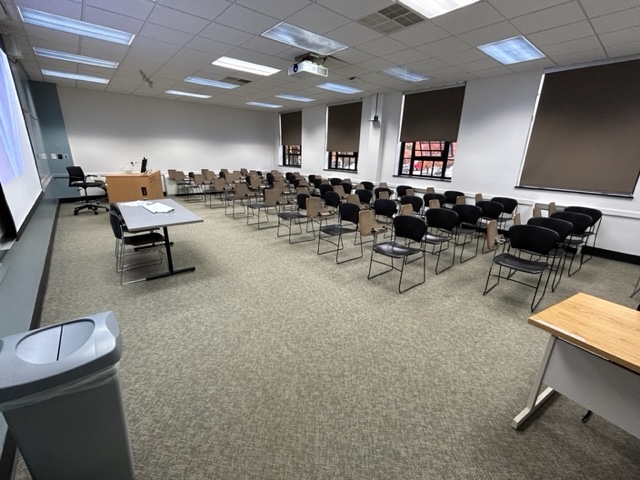 Back of the classroom with student desks in rows. Large windows are on the back wall.
