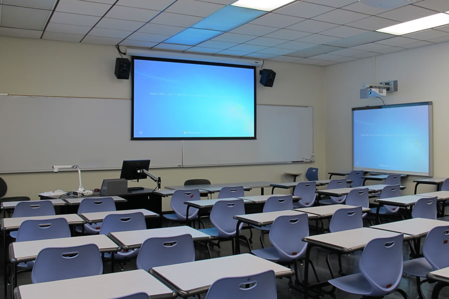 Fenton 180 Front of the classroom with a large projector screen and white board.