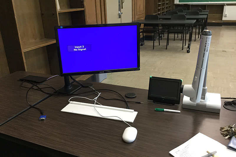 Mason 2018 Smart Classroom teachers station with a computer and projector controller.