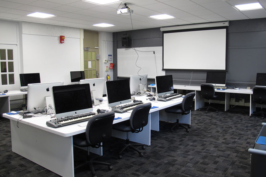 Front of the classroom with a large whiteboard and projector screen