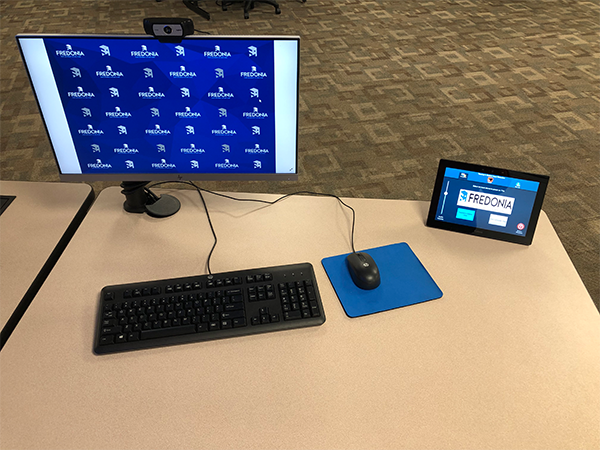 Desk with a computer, mouse, keyboard and projector controller