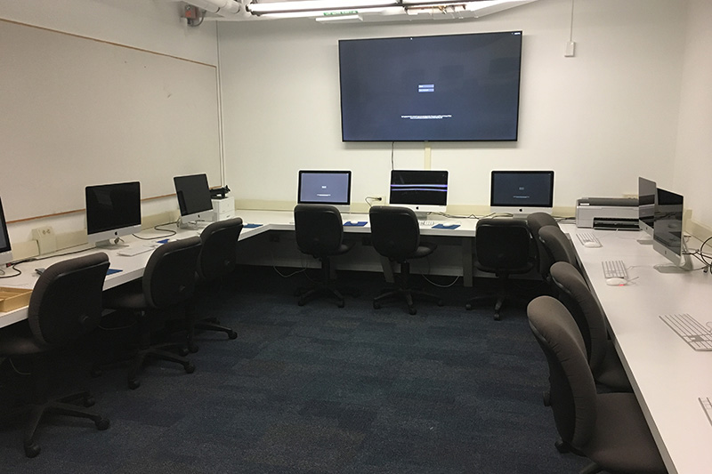 Front of the computer lab with a large tv and computers to use.