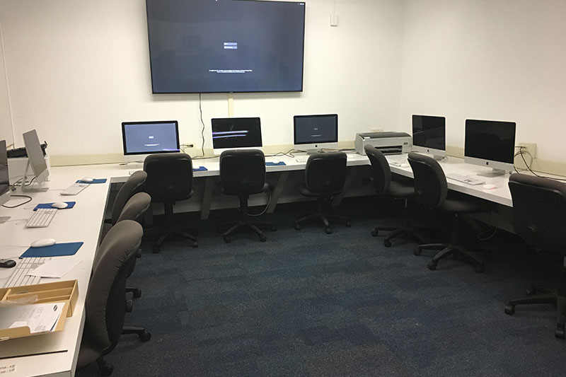 Front of the computer lab with a large tv and computers to use.