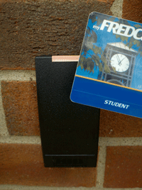 FRED Card next to a card scanner mounted on a brick wall