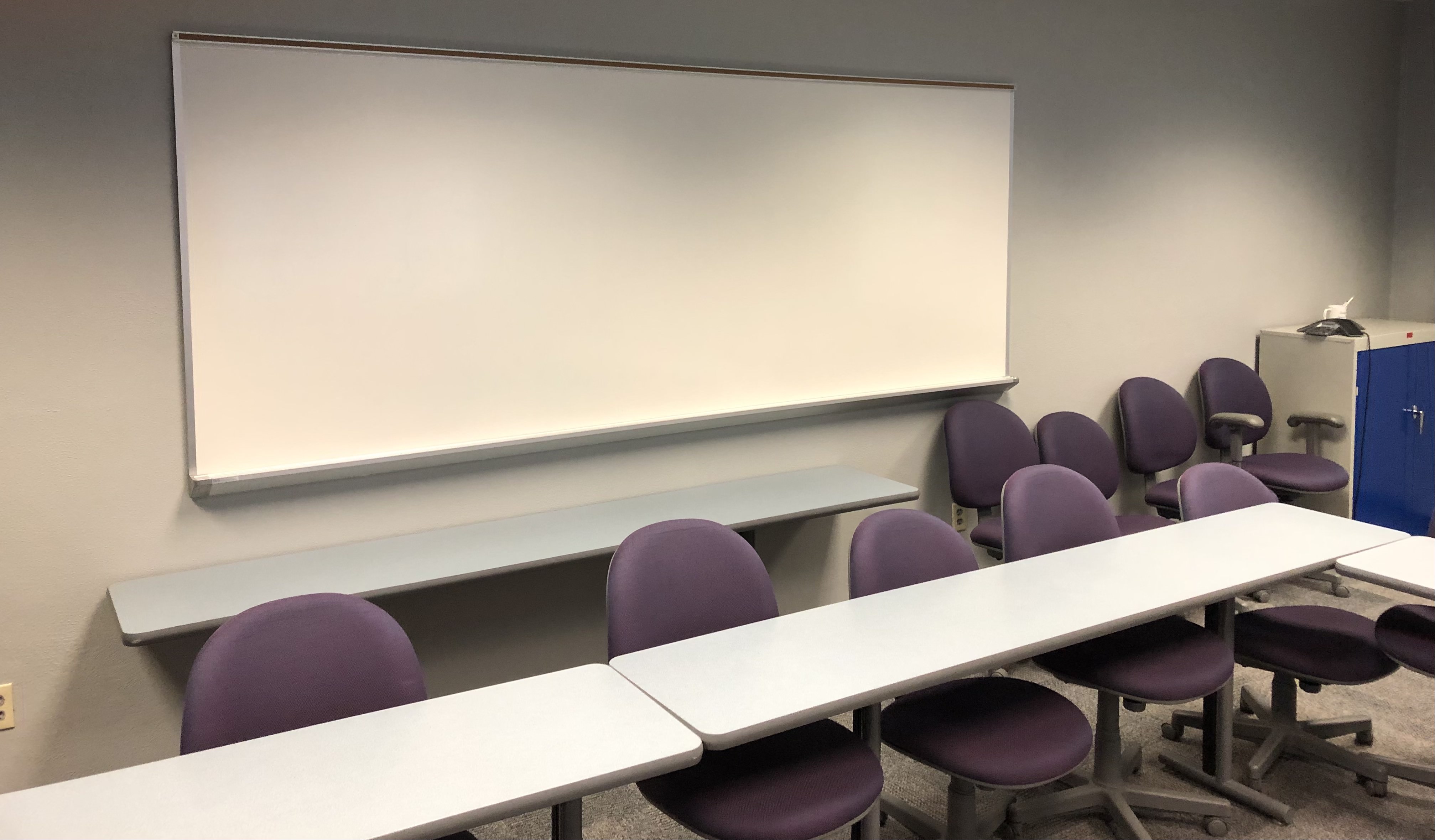 Student seating with a white board on the wall