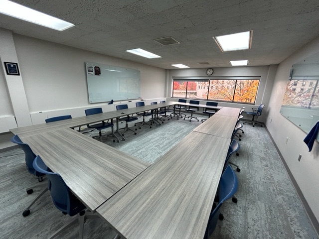 Conference table and chairs with a large window on the back wall.