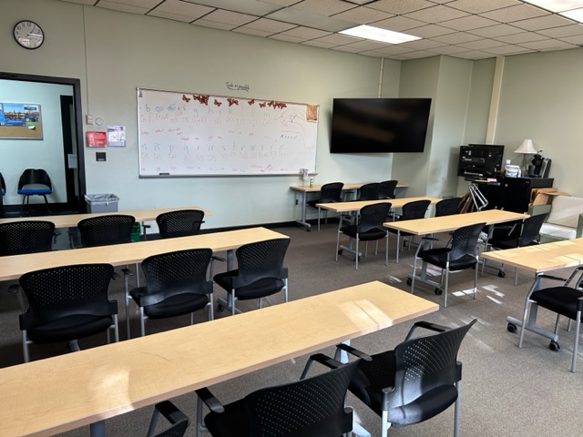 Front of the classroom with a large white board and TV.
