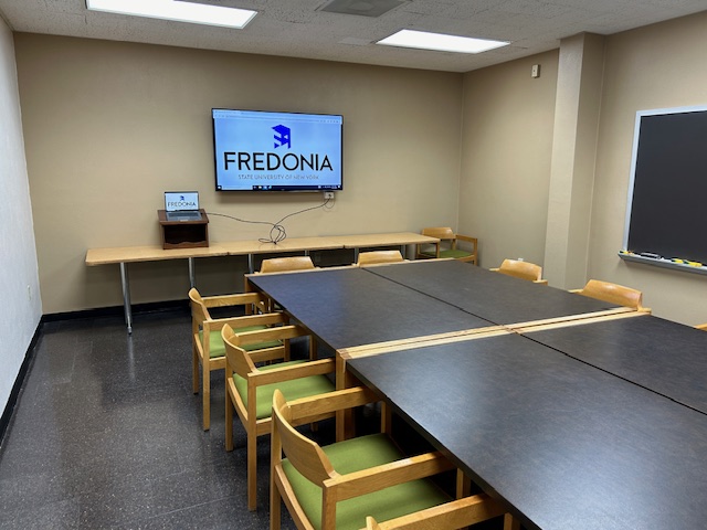 Front of the conference room with a large tv.