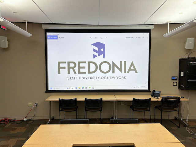 Front of the conference room with a large projector screen