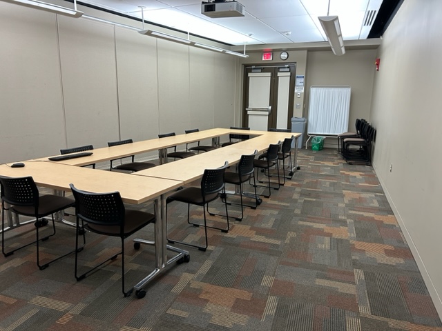 Conference Room with tables, chairs, and a projector screen.