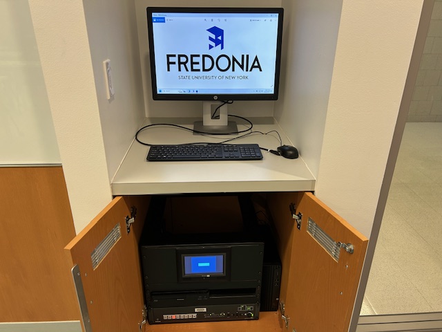Teachers computer station next to an Extron switcher rack
